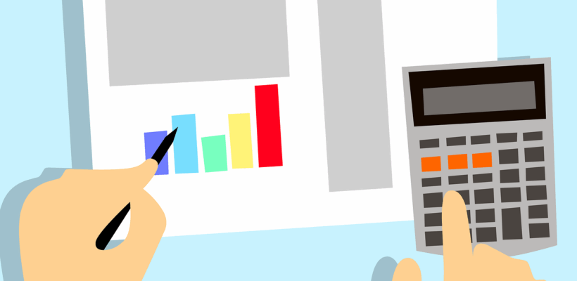 overhead view of hands making calculations with a nondescript chart